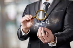 a man in a suit holding a magnifying glass.